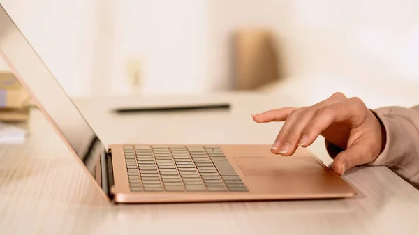 Cropped view of woman using laptop with blank screen on table — Stock Photo