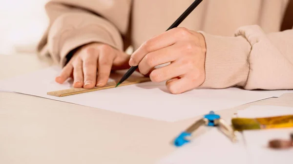 Vue recadrée du dessin de la femme avec crayon et règle près de la boussole à la maison — Photo de stock