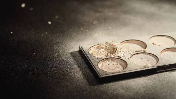 Vue rapprochée de la palette avec poudre pour le visage écrasée sur fond noir — Photo de stock