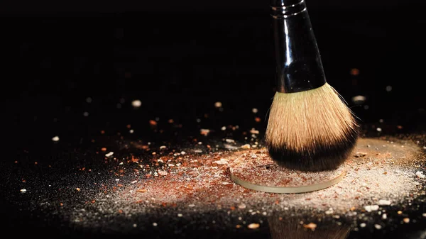 Close up view of face powder and cosmetic brush on black background — Stock Photo