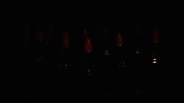 Червоні помади в темряві на чорному тлі з пробілом для копіювання — стокове фото