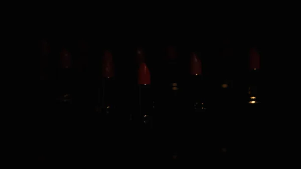 Red lipsticks in darkness on black background with copy space — Stock Photo