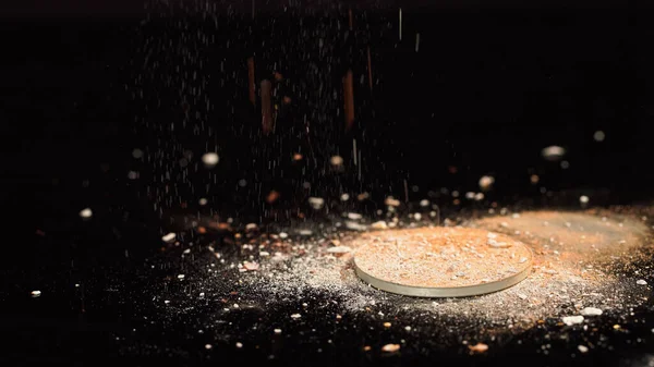 Close up view of blurred face powder pouring on black background — Stock Photo