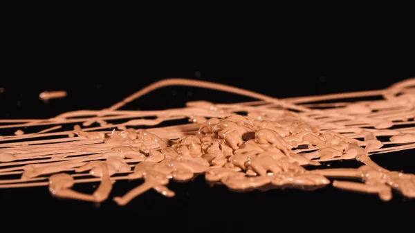 Close up view of liquid makeup concealer on black surface — Stock Photo