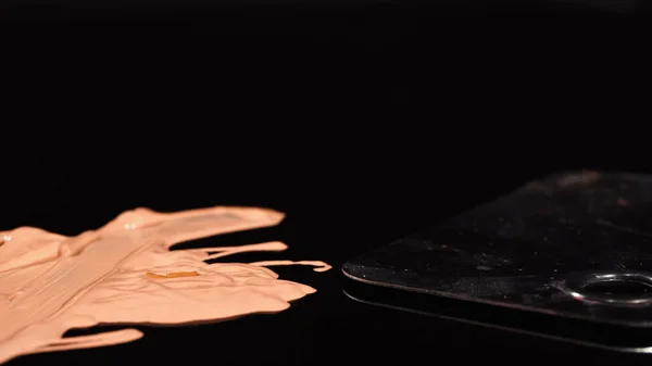 Vue rapprochée de la palette et du fond de teint liquide sur fond noir — Photo de stock