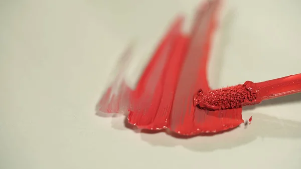 Vista de perto do aplicador e gloss labial no fundo cinza — Fotografia de Stock