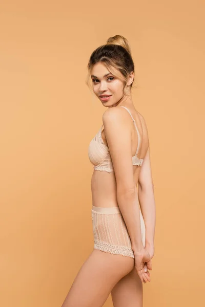 Femme souriante avec corps et peau parfaits posant en dentelle sous-vêtements isolés sur beige — Photo de stock