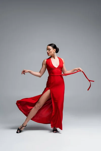 Dançarina de salão elegante executando tango em fundo cinza — Fotografia de Stock