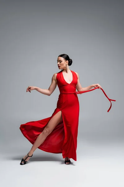 Stylish ballroom dancer performing tango on grey background — Stock Photo