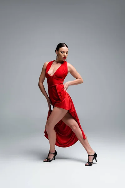 Professional dancer in heels performing tango choreography on grey background — Stock Photo