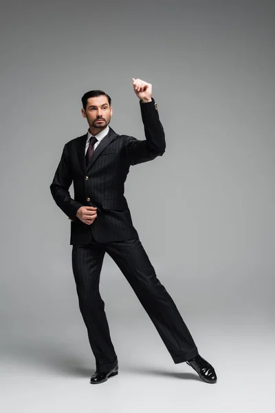 Full length of stylish ballroom dancer moving on grey background — Stock Photo