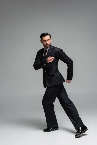 Full length of elegant ballroom dancer moving on grey background — Stock Photo