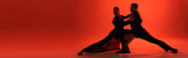 Silhueta de dançarinos que se movem sobre fundo vermelho com sombra, banner — Fotografia de Stock