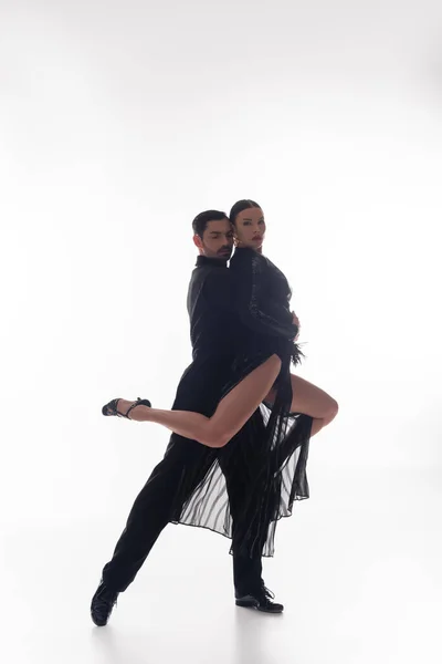 Ballroom dançarina levantar parceiro no vestido e saltos no fundo branco — Fotografia de Stock