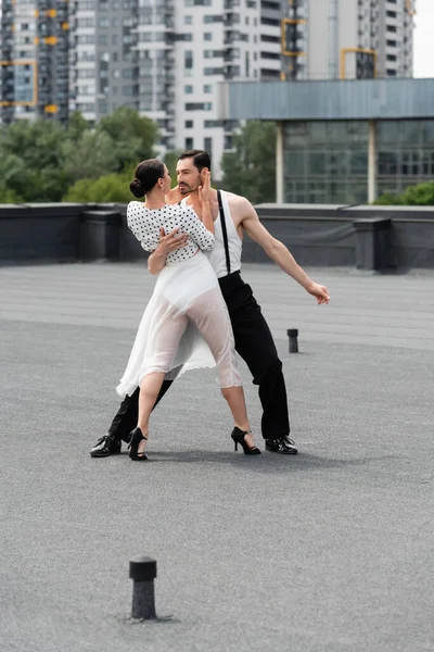 Professional ballroom dancers performing choreography on rooftop of building outdoors — Stock Photo