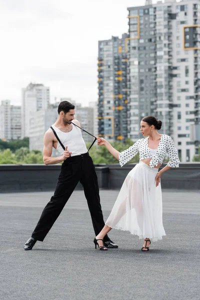 Bruna ballerina in tacchi esibendosi coreografia con partner sul tetto — Foto stock