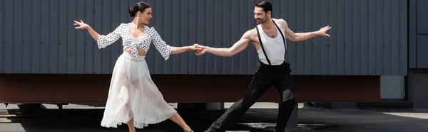 Pair of dancers performing choreography on roof of building, banner — Stock Photo