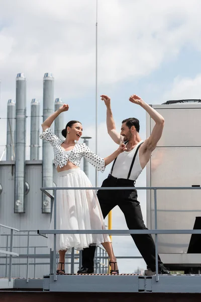 Positive and stylish professional dancers moving on rooftop of building outdoors — Stock Photo