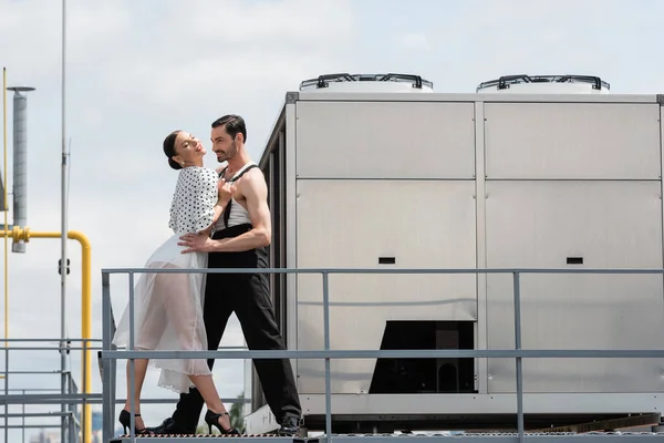 Stilvolle Gesellschaftstänzer führen Choreographien in der Nähe von Geländer auf Dach eines Gebäudes im Freien auf — Stockfoto