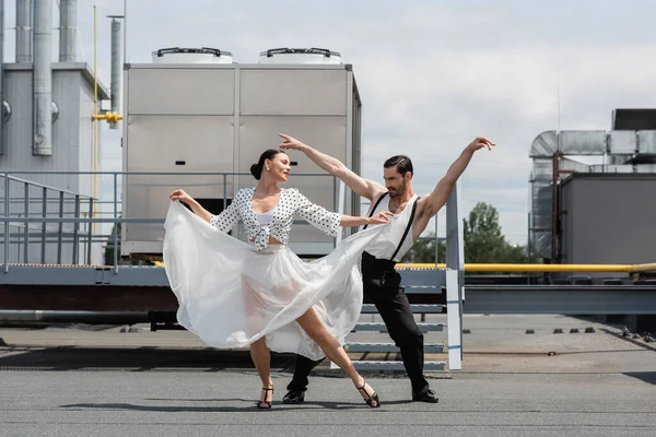 Positive and stylish dancers performing choreography on roof — Stock Photo