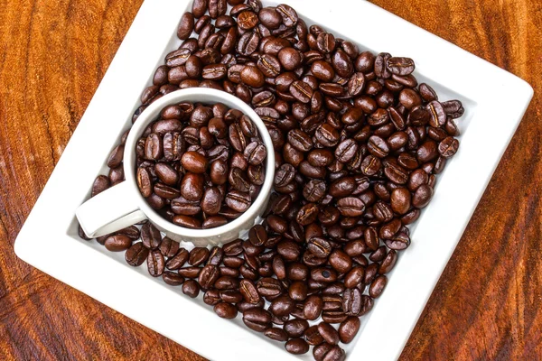 Kaffeebohnen auf dem hölzernen Hintergrund. — Stockfoto