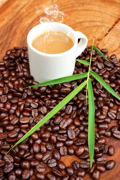 Café e grãos no fundo de madeira . — Fotografia de Stock