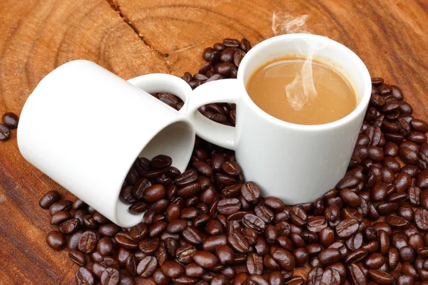 Kaffee und Bohnen auf dem hölzernen Hintergrund. — Stockfoto