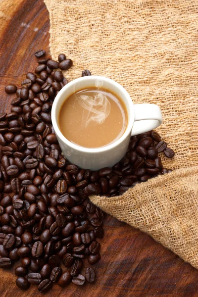 コーヒーと木製の背景上の豆. — ストック写真