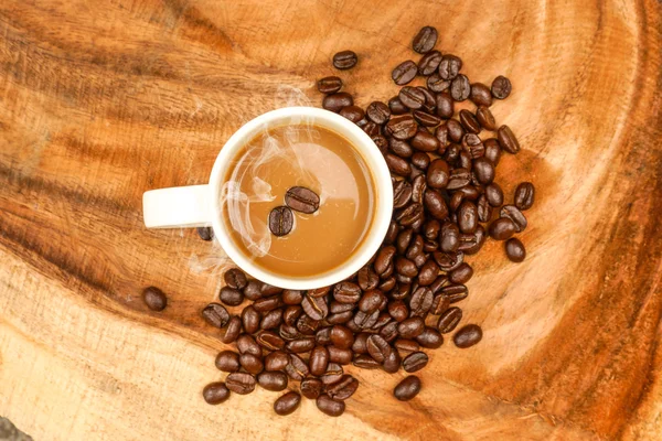 Koffie en bonen op de houten achtergrond. — Stockfoto