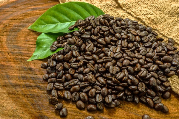 Kávová zrna na dřevěném pozadí. — Stock fotografie