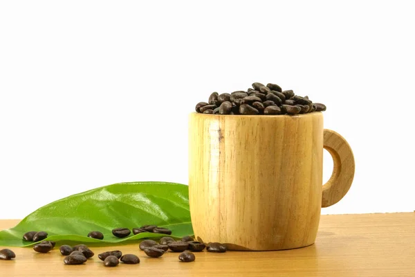 Koffie bonen in een glas hout op een houten oppervlak. — Stockfoto