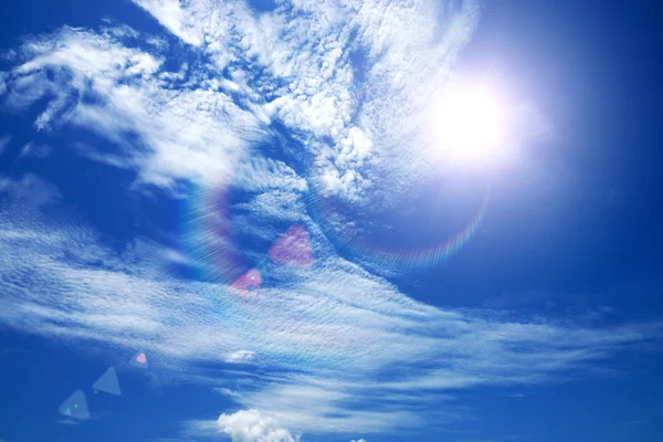 Blauwe hemel met wolken en zon. — Stockfoto