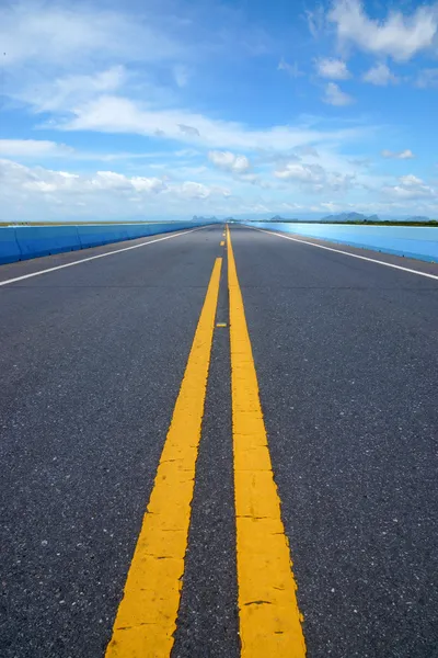 Blauwe lucht met kan lege weg en het verkeer lijnen. — Stockfoto