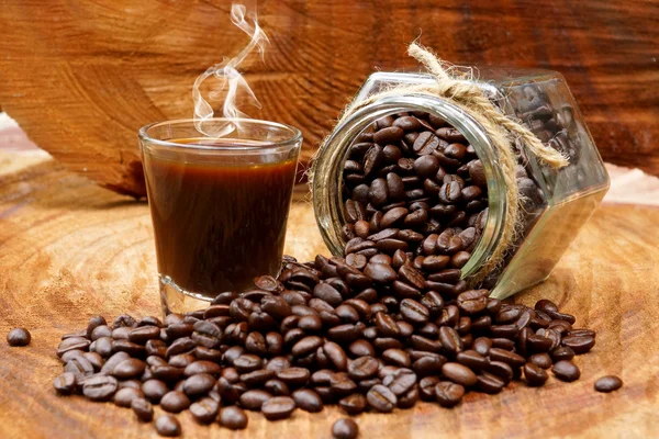 Roasted coffee beans on wood and black coffee. — Stock Photo, Image