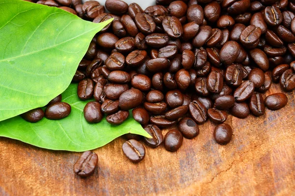 Pražená kávová zrna na dřevo. (káva arabica) — Stock fotografie