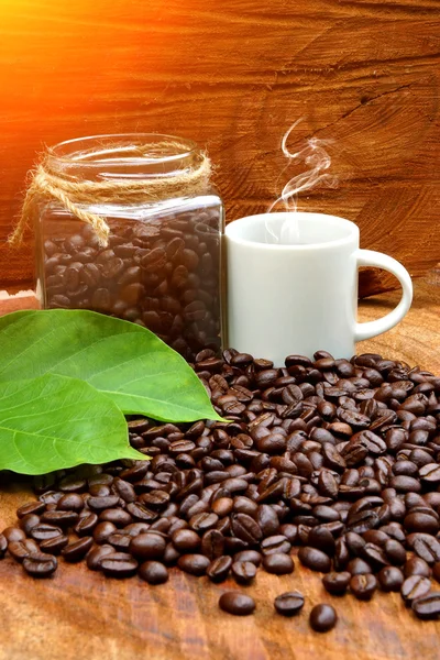 Biji kopi panggang di kayu dan kopi hitam di pagi hari . — Stok Foto