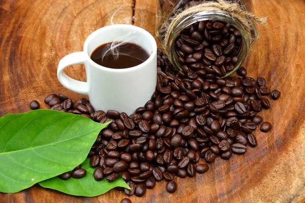 Grãos de café torrados em madeira e café preto . — Fotografia de Stock