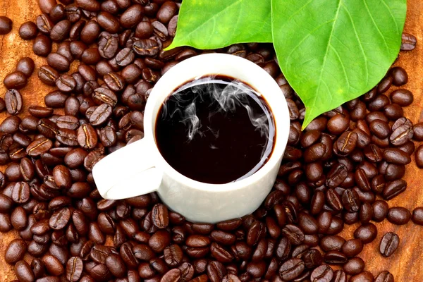 Смажені кавові зерна на дереві та чорній каві . — стокове фото