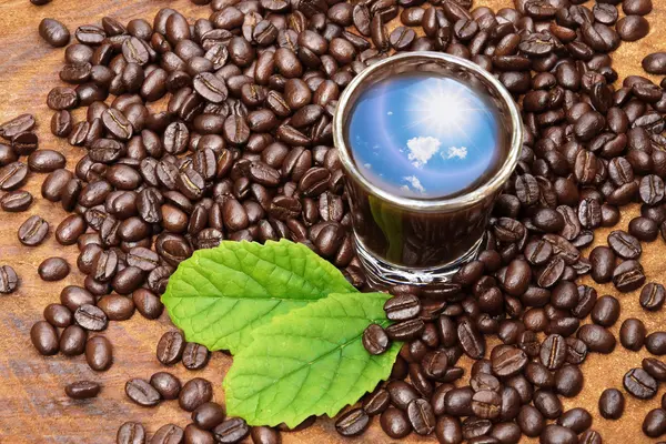 Roasted coffee beans on wood and black coffee. — Stock Photo, Image