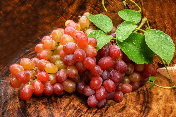 Uvas vermelhas frescas em madeira castanha . — Fotografia de Stock