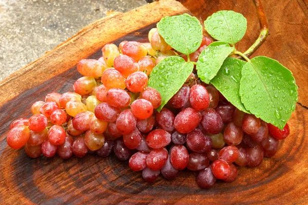 Rode druiven op bruin hout. — Stockfoto