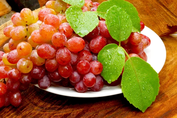 Frische rote Trauben auf braunem Holz. — Stockfoto