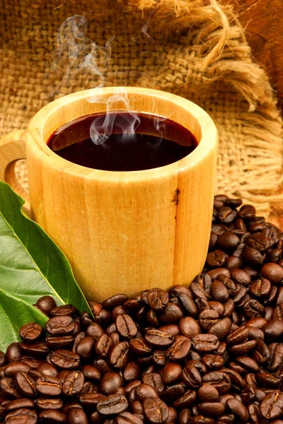 对玻璃木材中的木材和黑咖啡烘培的咖啡豆. — 图库照片