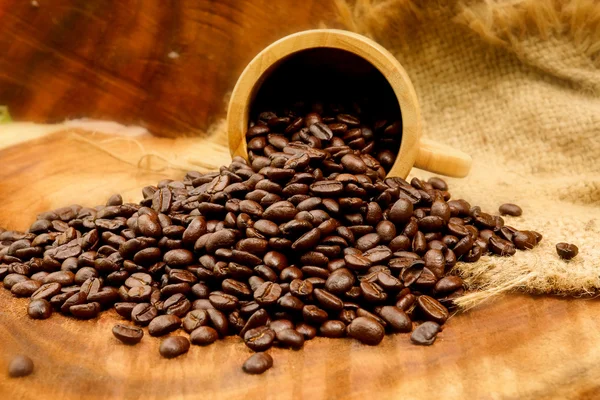 Pražená kávová zrna na dřevo. (káva arabica) — Stock fotografie