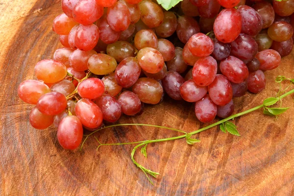 Frische rote Trauben auf braunem Holz. — Stockfoto