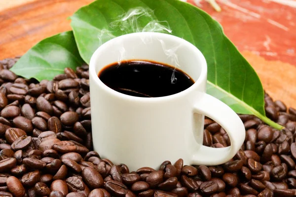 Kaffee und Kaffeebohnen auf Holz Hintergrund — Stockfoto