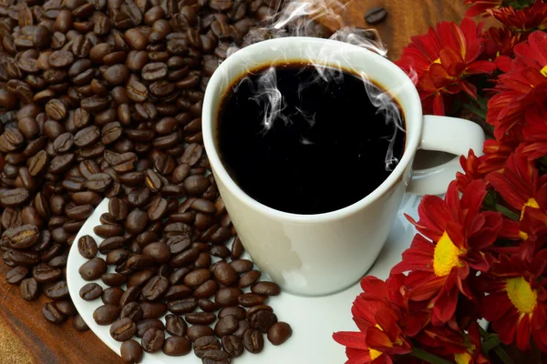 Taza de café y frijoles sobre un fondo de madera . — Foto de Stock