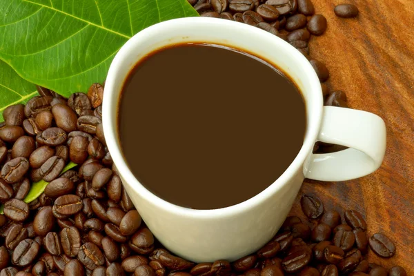コーヒー カップとウッドの背景上の豆. — ストック写真