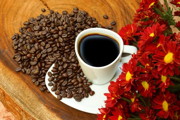 Tasse à café et haricots sur fond de bois . — Photo