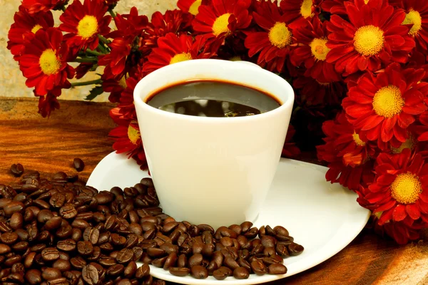 लाकूड पार्श्वभूमीवर कॉफी कप आणि बीन्स . — स्टॉक फोटो, इमेज